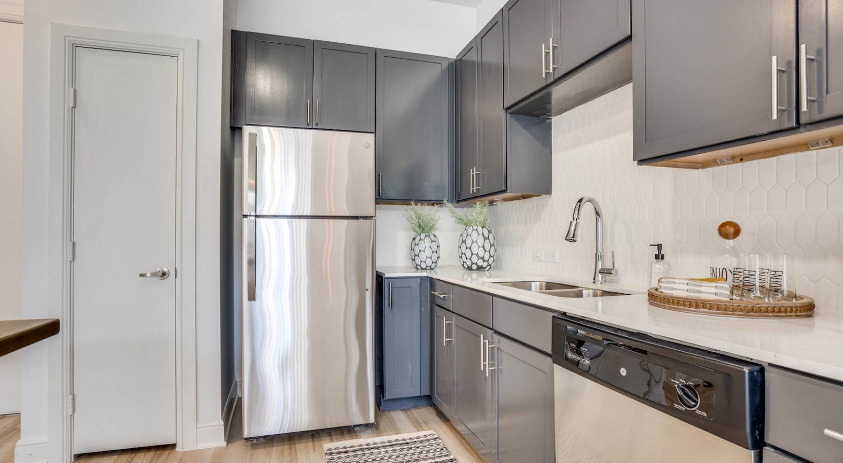 a kitchen with stainless steel appliances and gray cabinets at The NEO Midtown