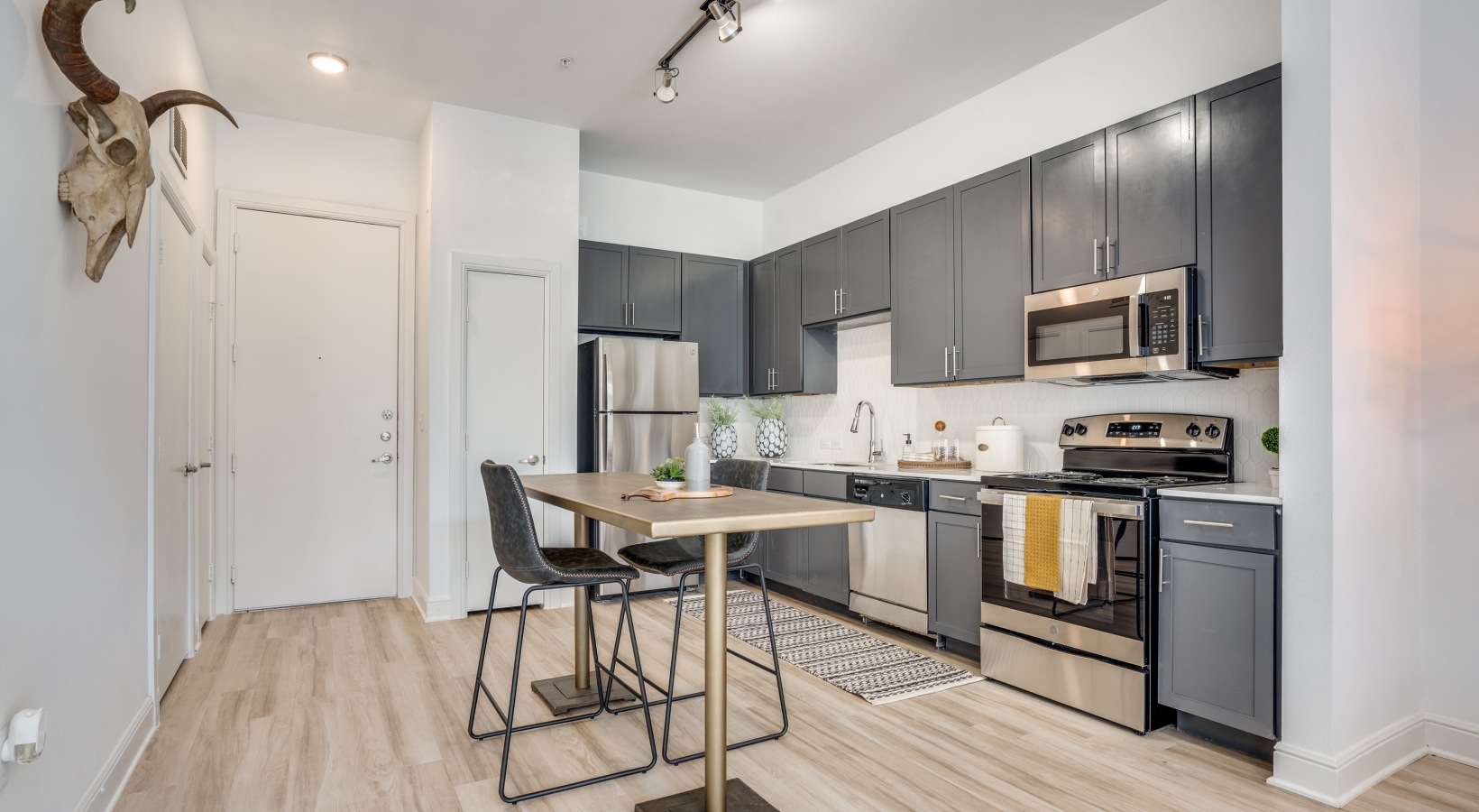 a kitchen with stainless steel appliances and wood floors at The NEO Midtown