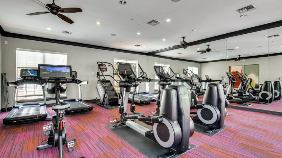 a gym room with tread machines and exercise equipment at The NEO Midtown